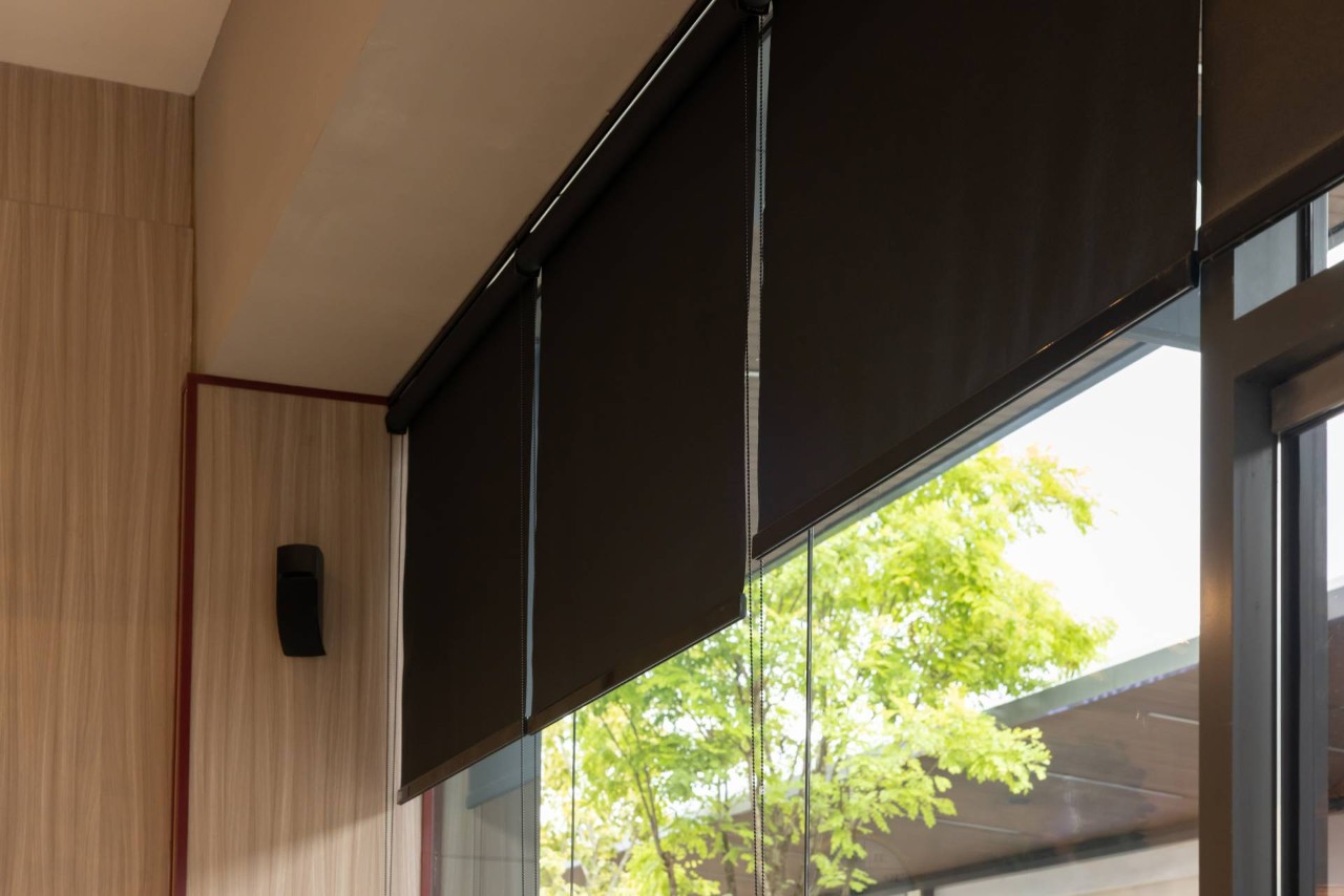 A large window with three black fabric roller shades at Little's Custom Blinds & Shutters near Brunswick, GA 